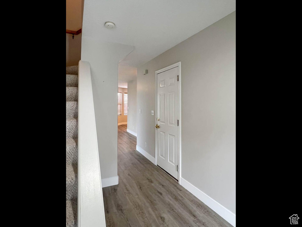 Corridor featuring wood finished floors, baseboards, and stairs