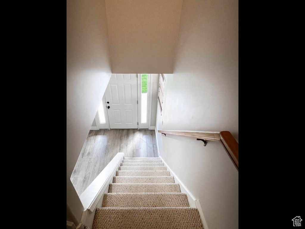 Stairs featuring wood finished floors and baseboards