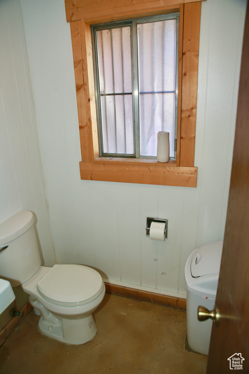 Half bathroom featuring toilet and concrete floors