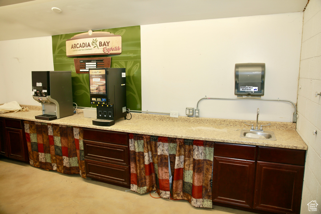 Bar featuring a sink and concrete flooring