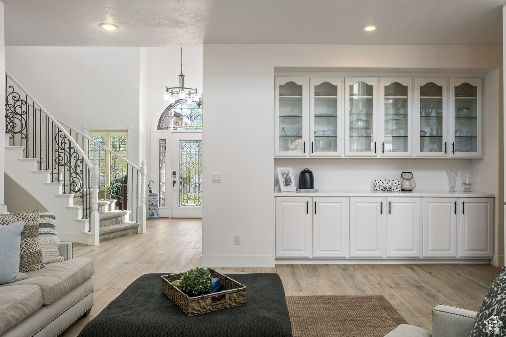 Living room featuring an inviting chandelier, recessed lighting, stairway, and light wood-type flooring