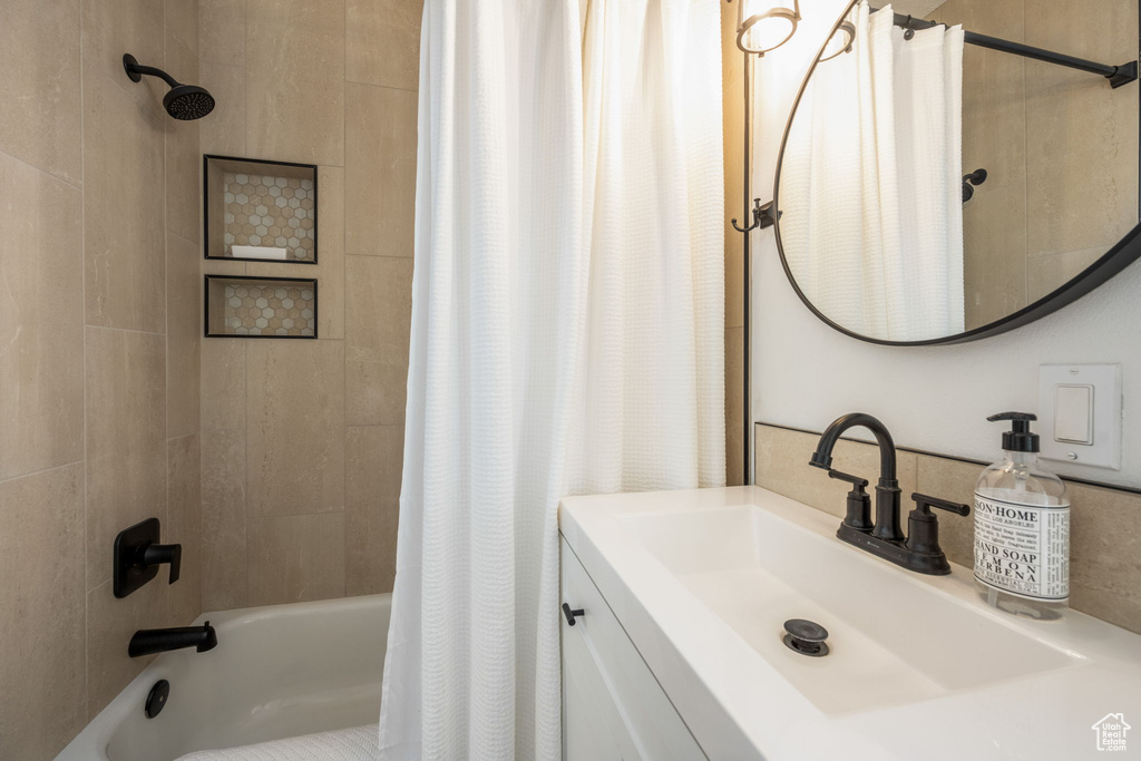 Bathroom featuring shower / bathtub combination with curtain and vanity