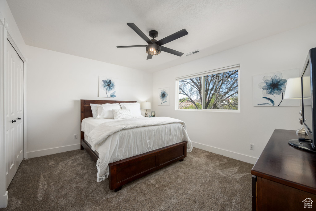 Bedroom featuring dark carpet, baseboards, and visible vents