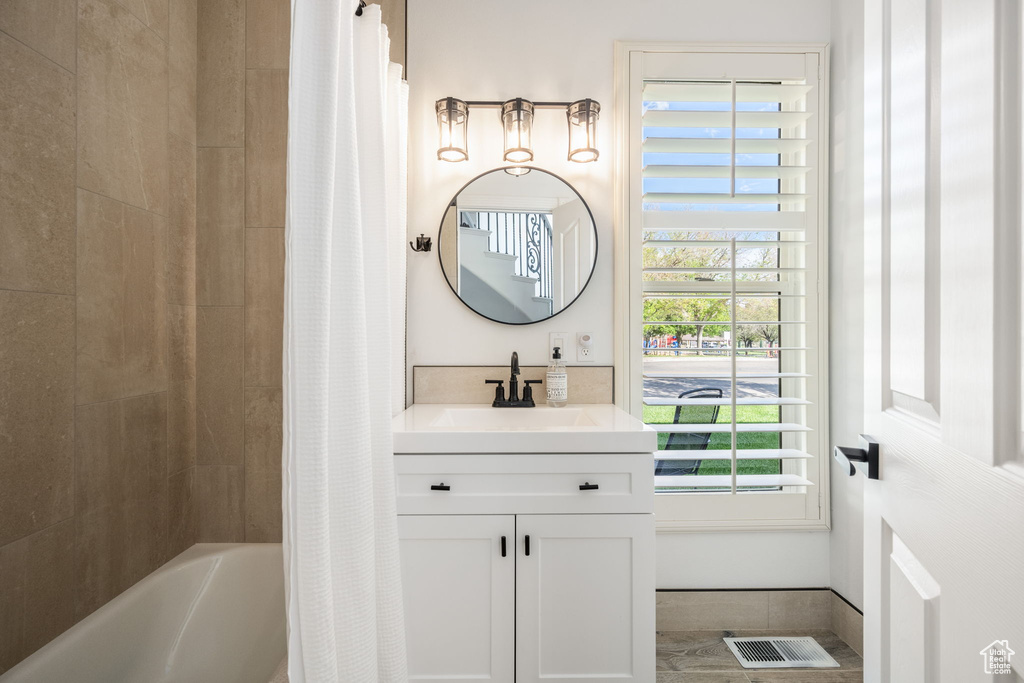 Full bath with shower / bath combo, visible vents, and vanity
