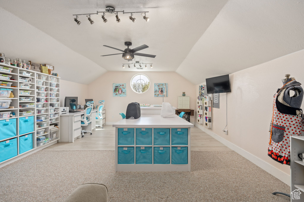 Home office with rail lighting, lofted ceiling, baseboards, ceiling fan, and light carpet