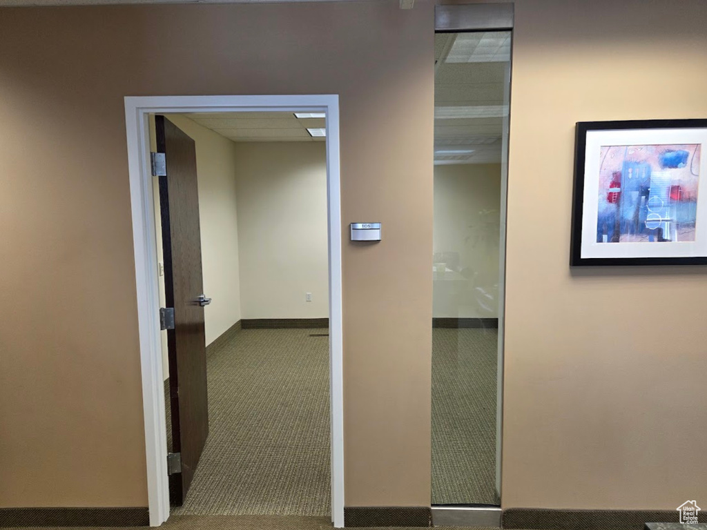 Corridor with carpet flooring and baseboards