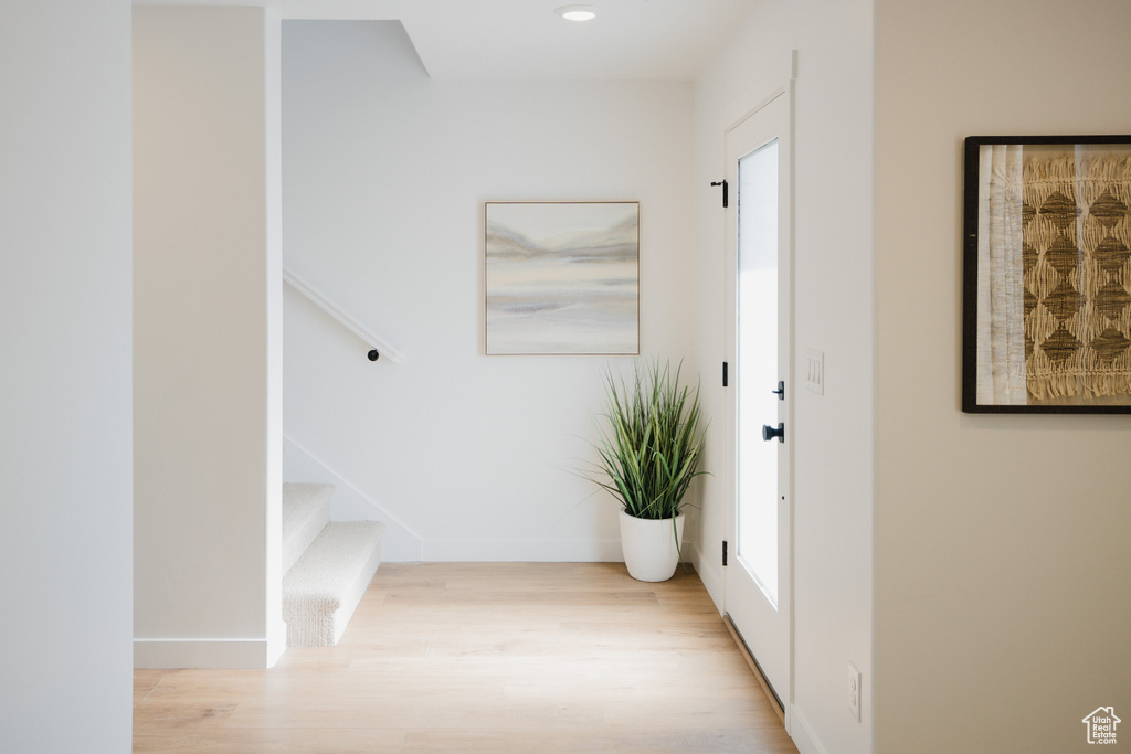 Entryway with stairs, baseboards, and wood finished floors