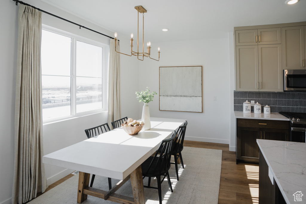 Dining room featuring a chandelier, recessed lighting, baseboards, and wood finished floors