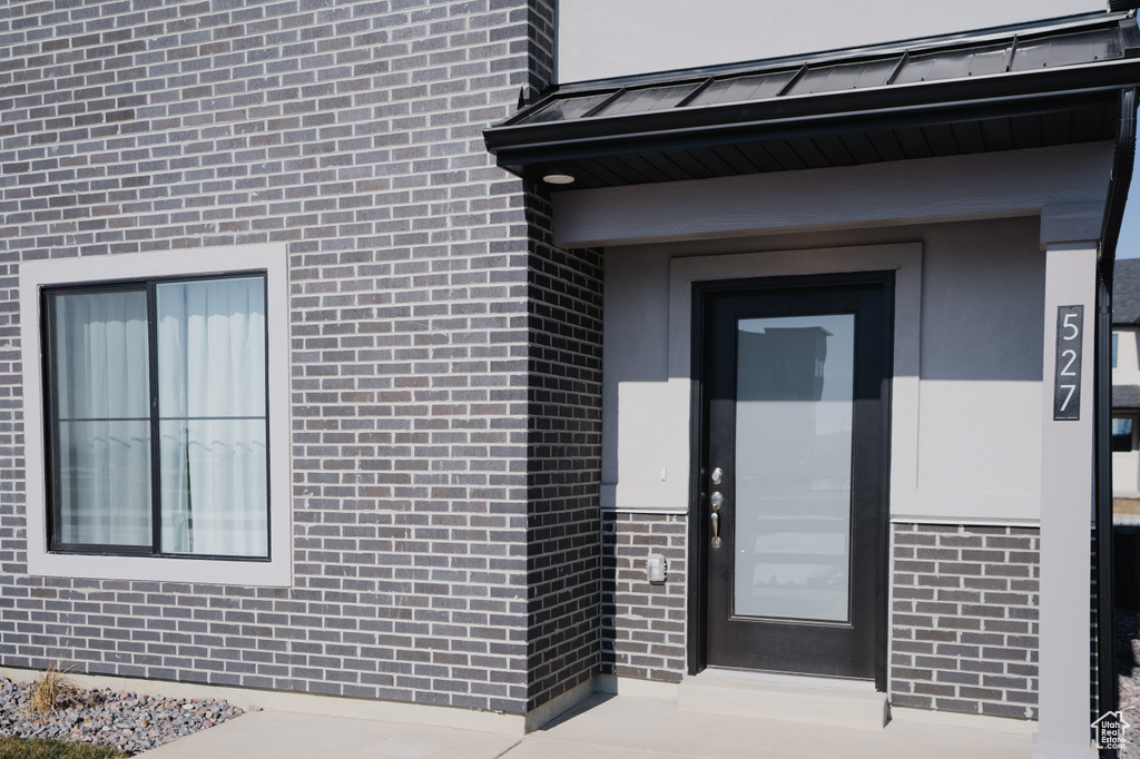 View of exterior entry with brick siding