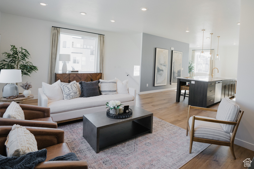 Living room with baseboards, recessed lighting, and light wood-style floors