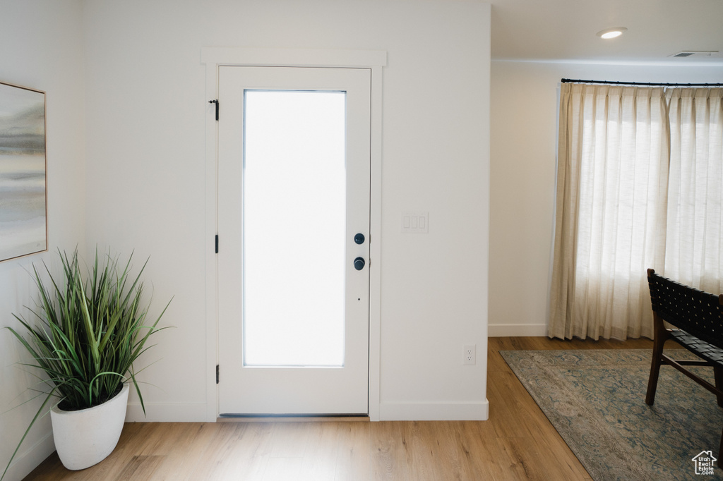 Entrance foyer with wood finished floors, baseboards, and visible vents