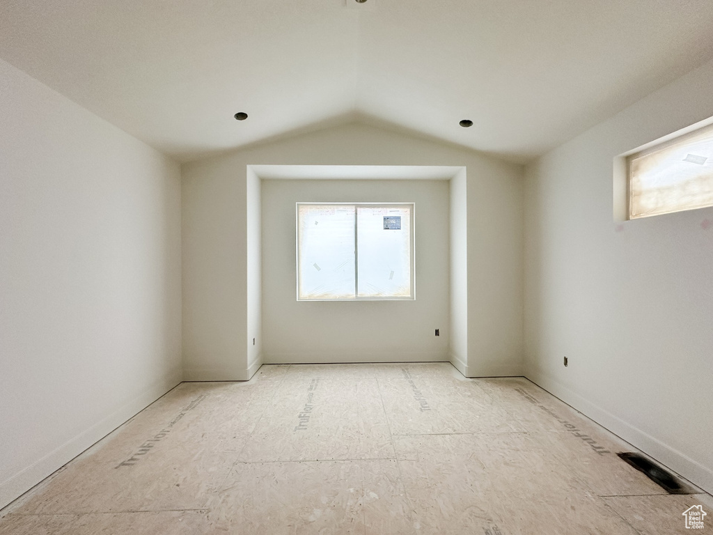 Spare room featuring visible vents and vaulted ceiling