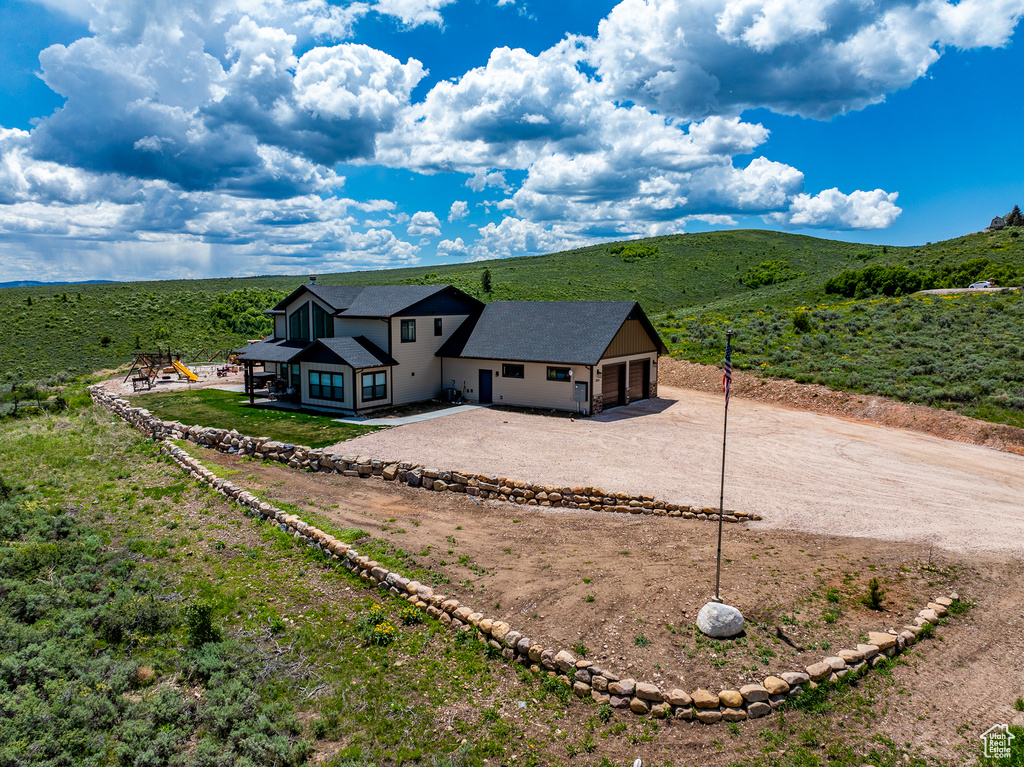 Aerial view of property and surrounding area featuring mountains
