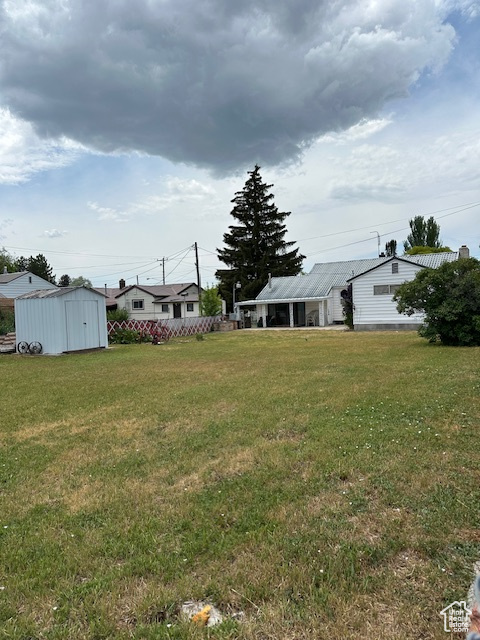 View of green lawn featuring a shed