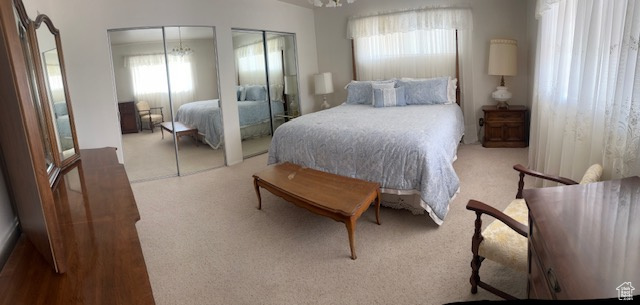 Bedroom with multiple windows, multiple closets, and carpet flooring