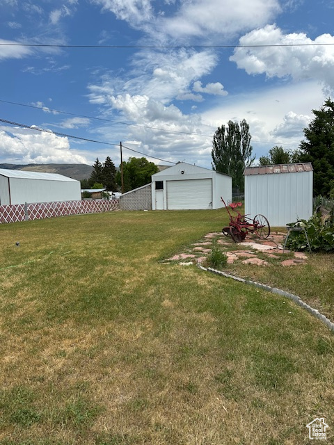 View of yard with an outdoor structure and a garage