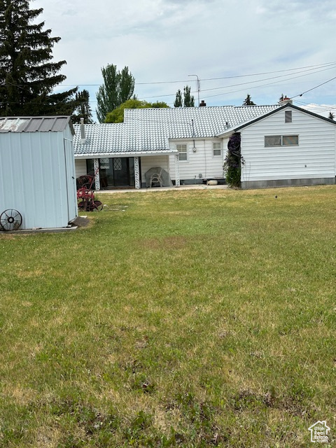 View of green lawn featuring a shed