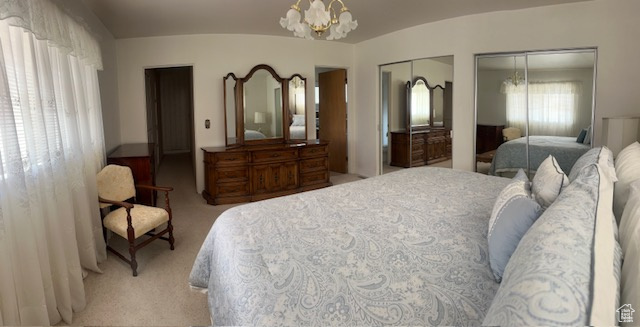 Bedroom with a chandelier, two closets, and light carpet