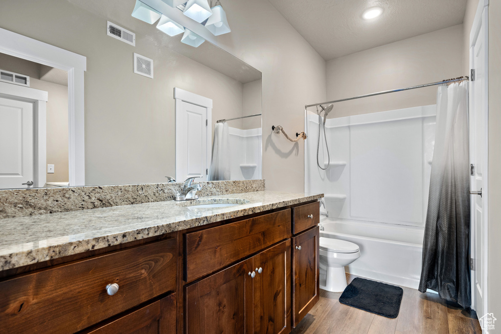 Full bath featuring visible vents, vanity, and wood finished floors