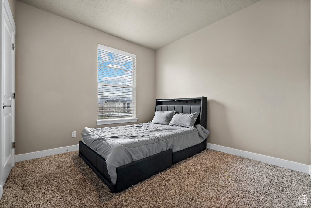 Carpeted bedroom featuring baseboards