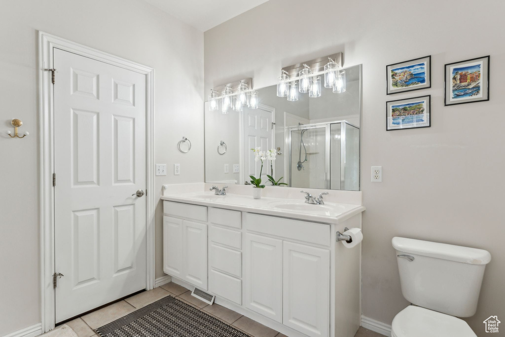 Full bathroom featuring a shower stall, tile patterned flooring, a sink, and toilet