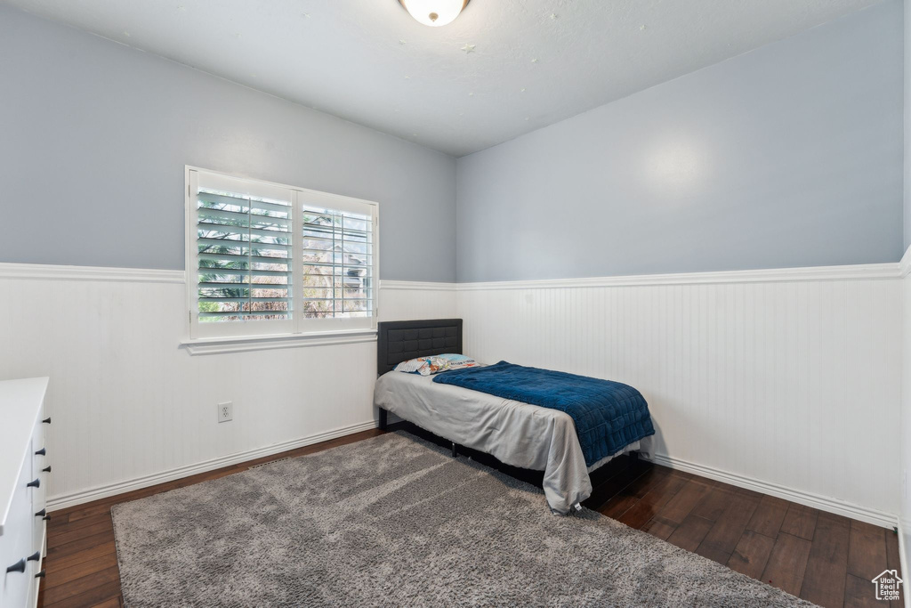 Bedroom featuring hardwood / wood-style flooring and a wainscoted wall