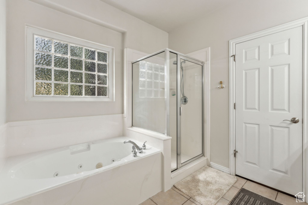 Bathroom featuring a whirlpool tub, tile patterned floors, and a shower stall
