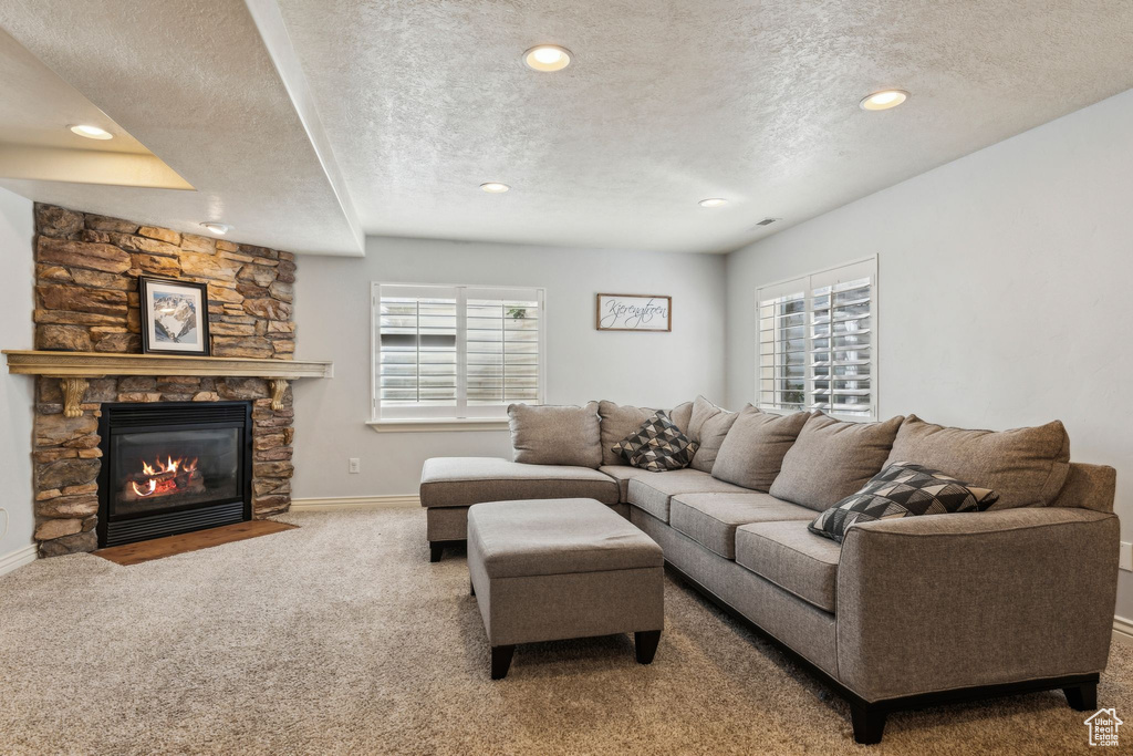 Living room featuring a textured ceiling, carpet flooring, and baseboards