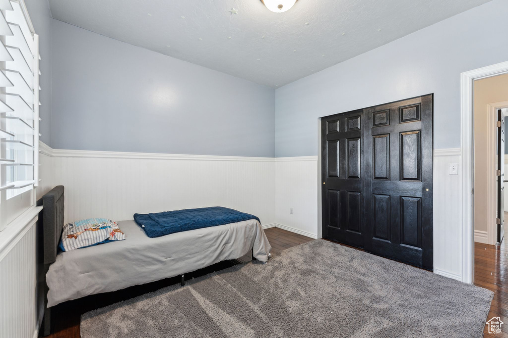 Bedroom with wainscoting and wood finished floors