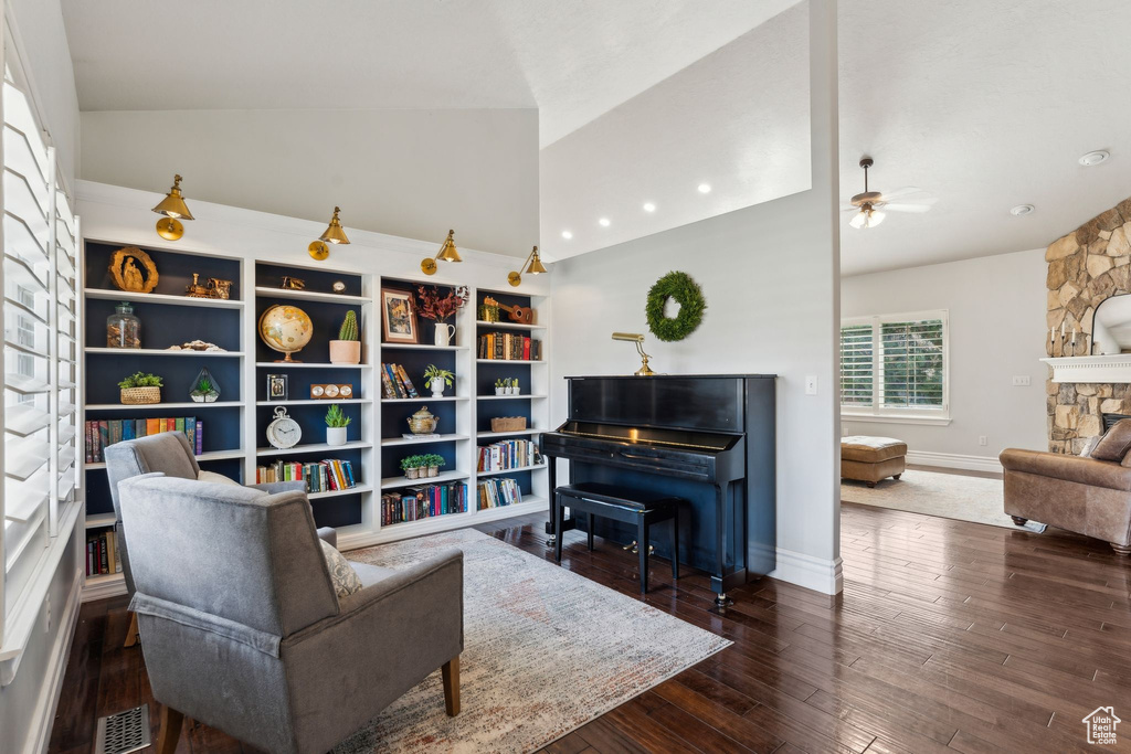Living area with visible vents, baseboards, a ceiling fan, hardwood / wood-style floors, and lofted ceiling