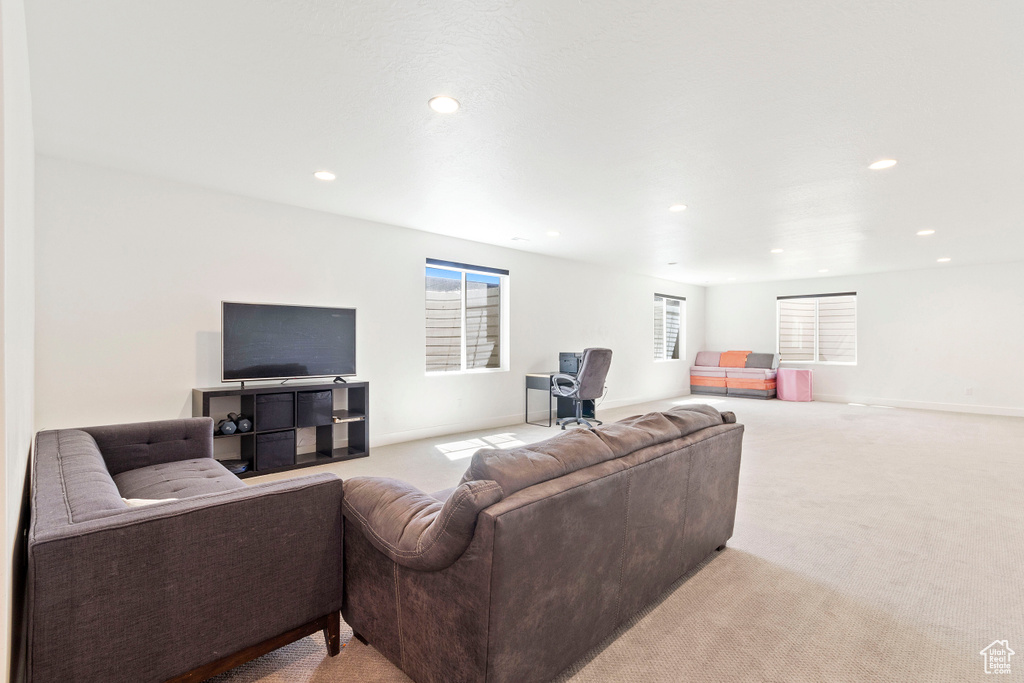 Living area with light carpet, baseboards, and recessed lighting