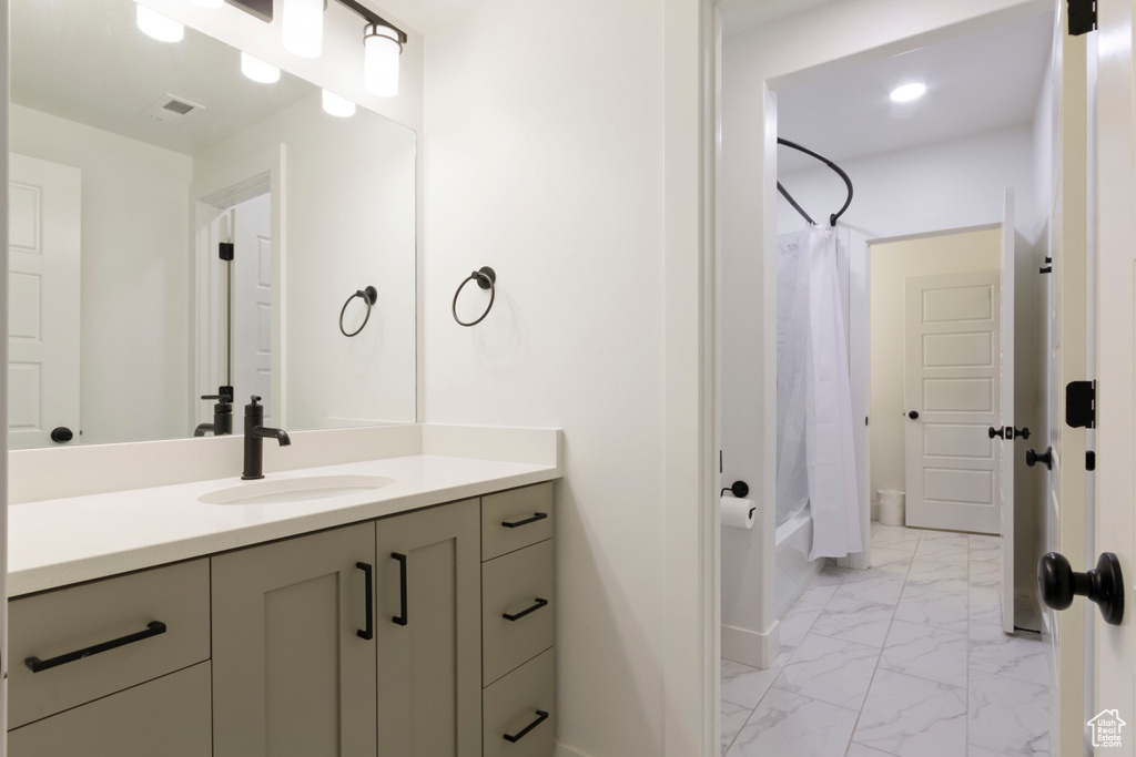 Full bath featuring visible vents, baseboards, shower / bathtub combination with curtain, vanity, and marble finish floor