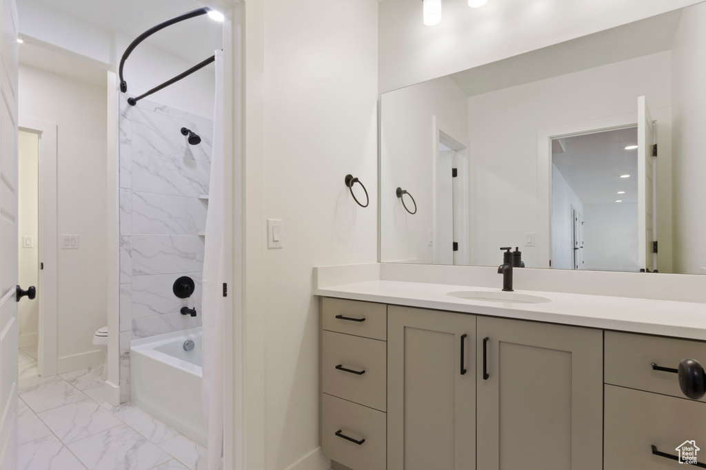 Bathroom with vanity,  shower combination, toilet, marble finish floor, and baseboards