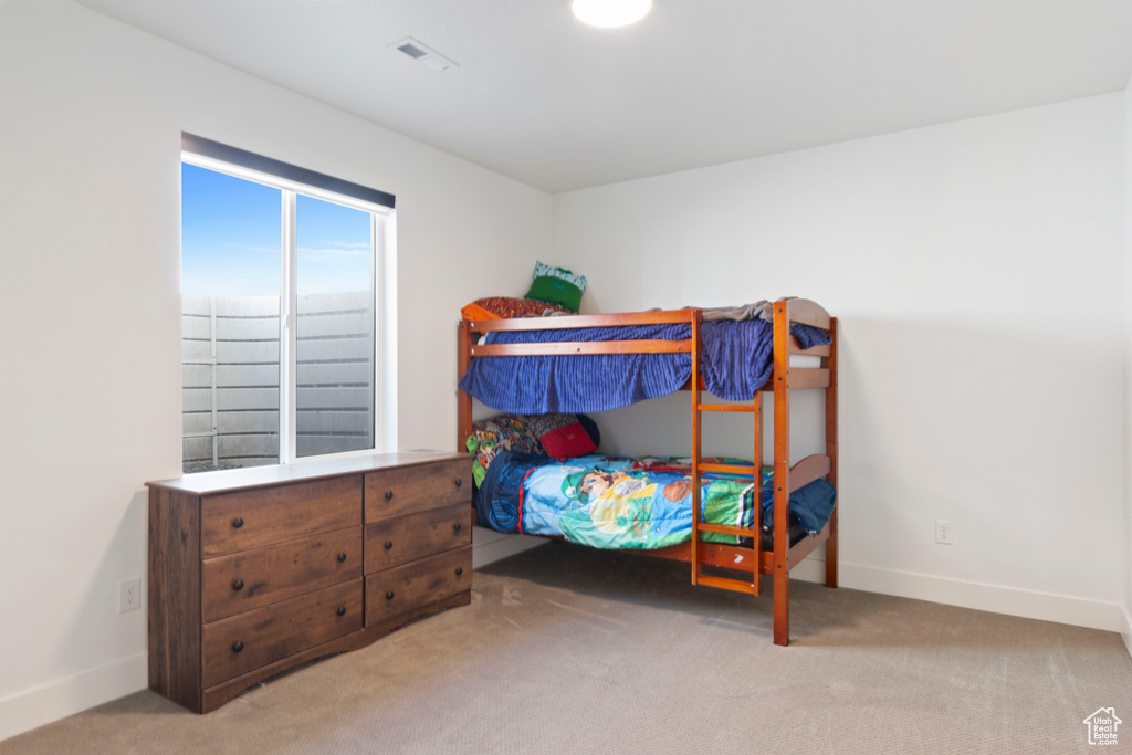 Carpeted bedroom featuring visible vents and baseboards
