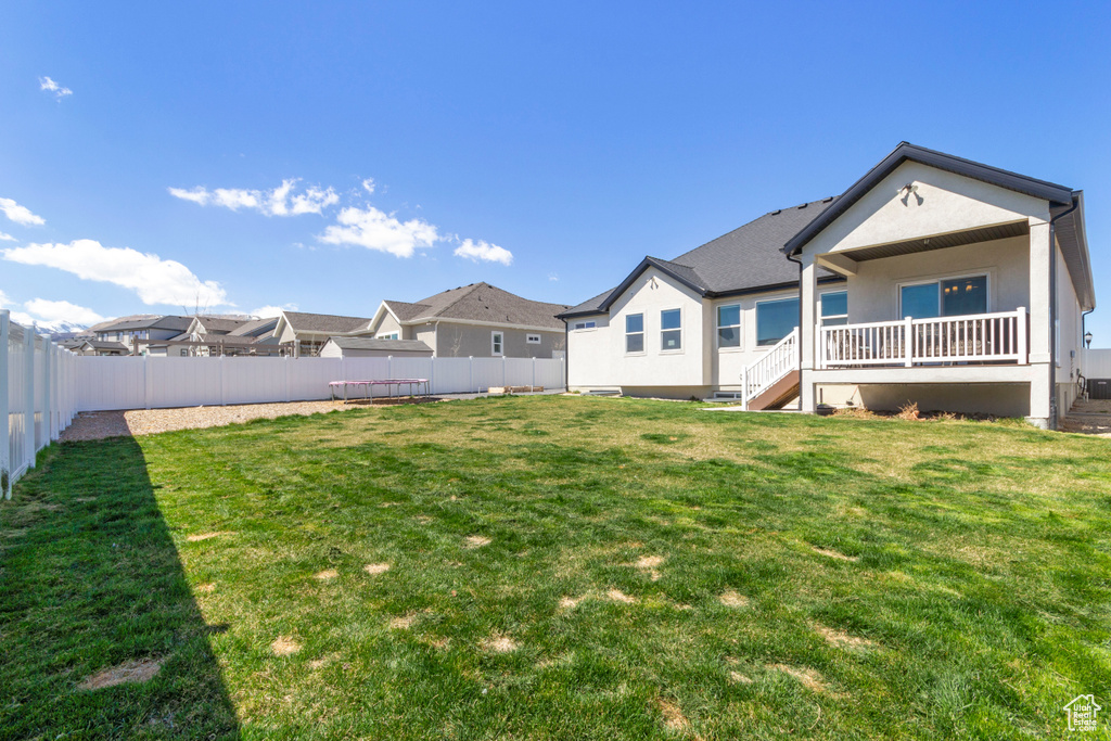 Rear view of property with a residential view, a fenced backyard, stucco siding, and a lawn
