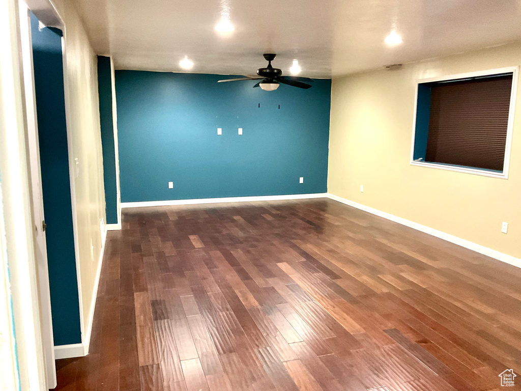 Unfurnished room featuring ceiling fan, wood finished floors, and baseboards