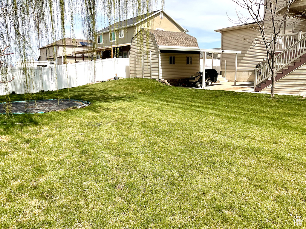 View of yard with a patio area, an outdoor structure, and a storage shed