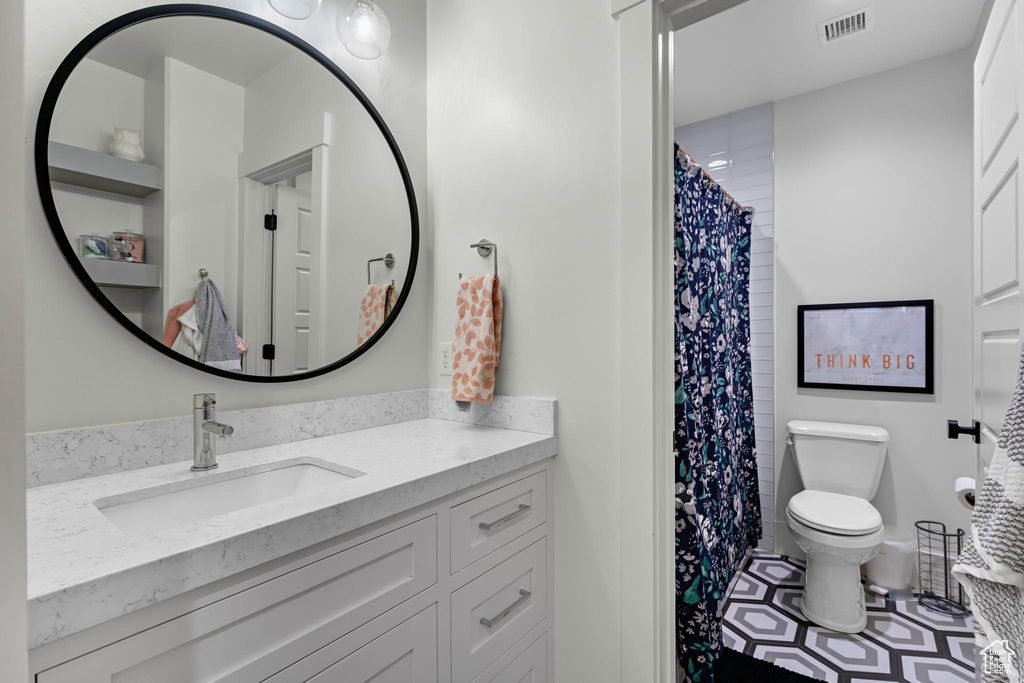 Full bathroom featuring vanity, tile patterned floors, a shower with curtain, toilet, and visible vents