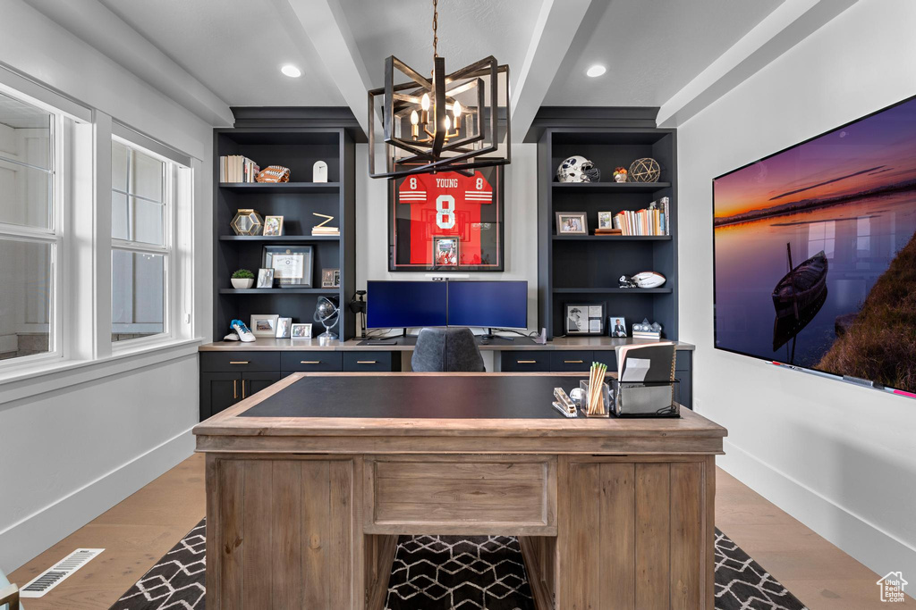 Office featuring built in features, visible vents, wood finished floors, baseboards, and a notable chandelier