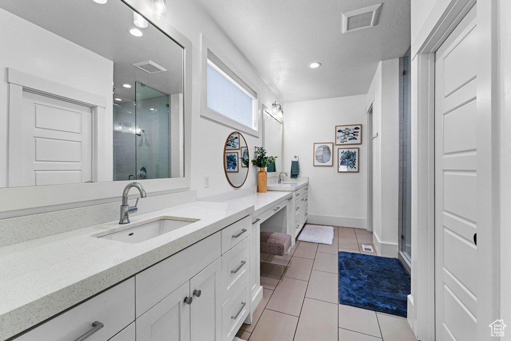 Bathroom with tile patterned floors, vanity, visible vents, and a stall shower