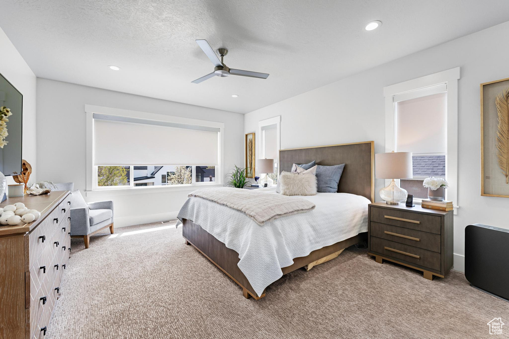 Carpeted bedroom featuring recessed lighting, a textured ceiling, and a ceiling fan