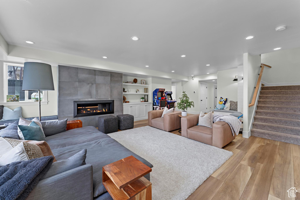 Living area with stairway, recessed lighting, light wood-style floors, and a fireplace