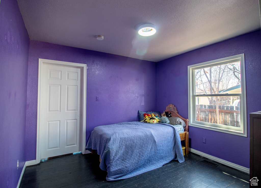 Bedroom with wood finished floors and baseboards