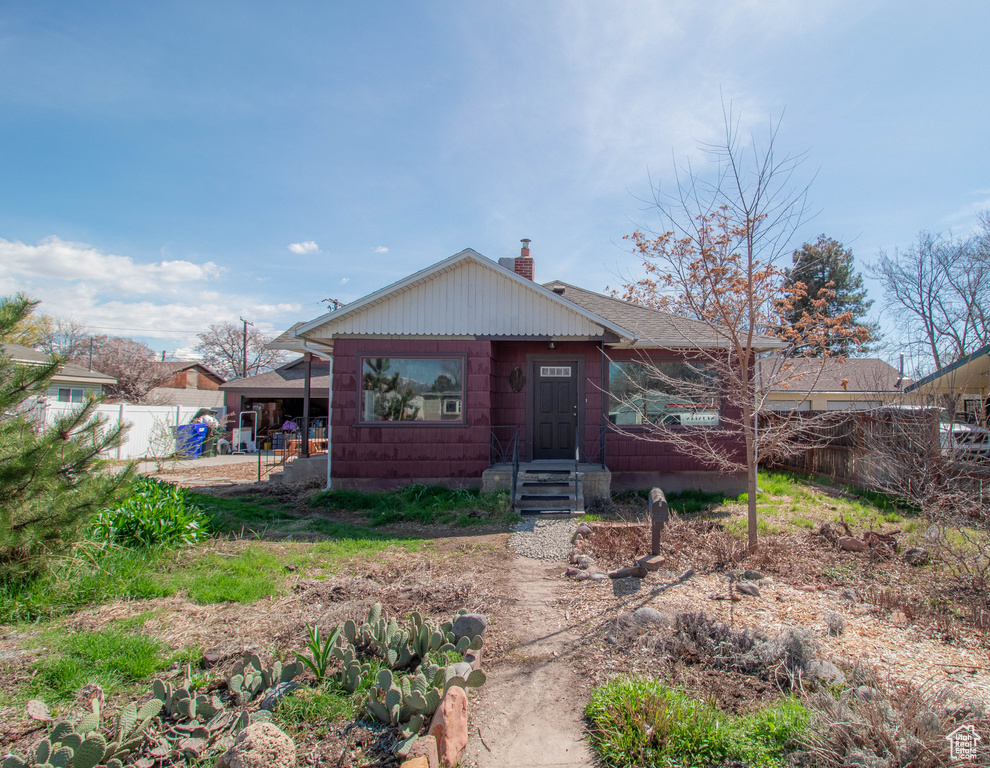 Rear view of property with fence, a chimney, and a shingled roof