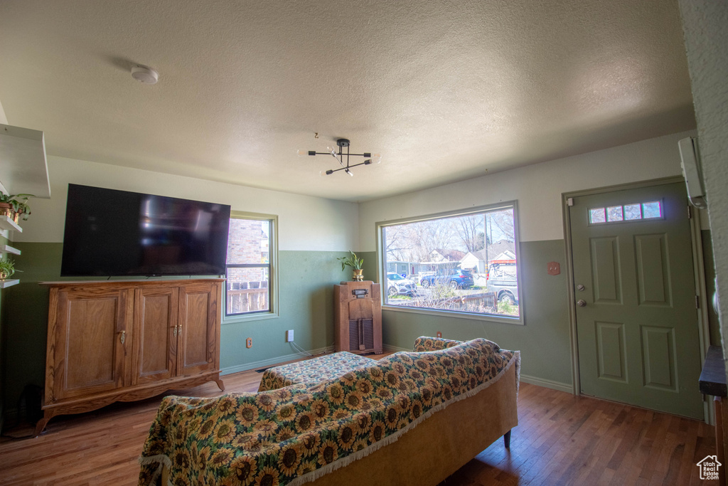 Bedroom featuring a textured ceiling, wood finished floors, and baseboards