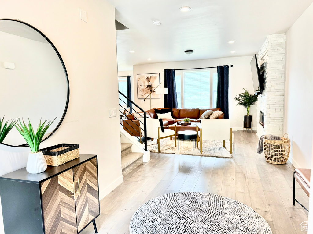 Living area with stairway, light wood-style flooring, recessed lighting, and baseboards