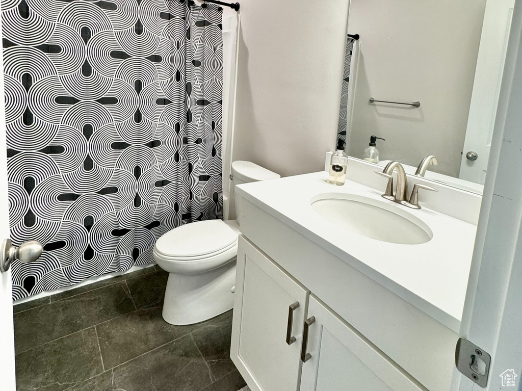 Bathroom with vanity, toilet, and a shower with curtain