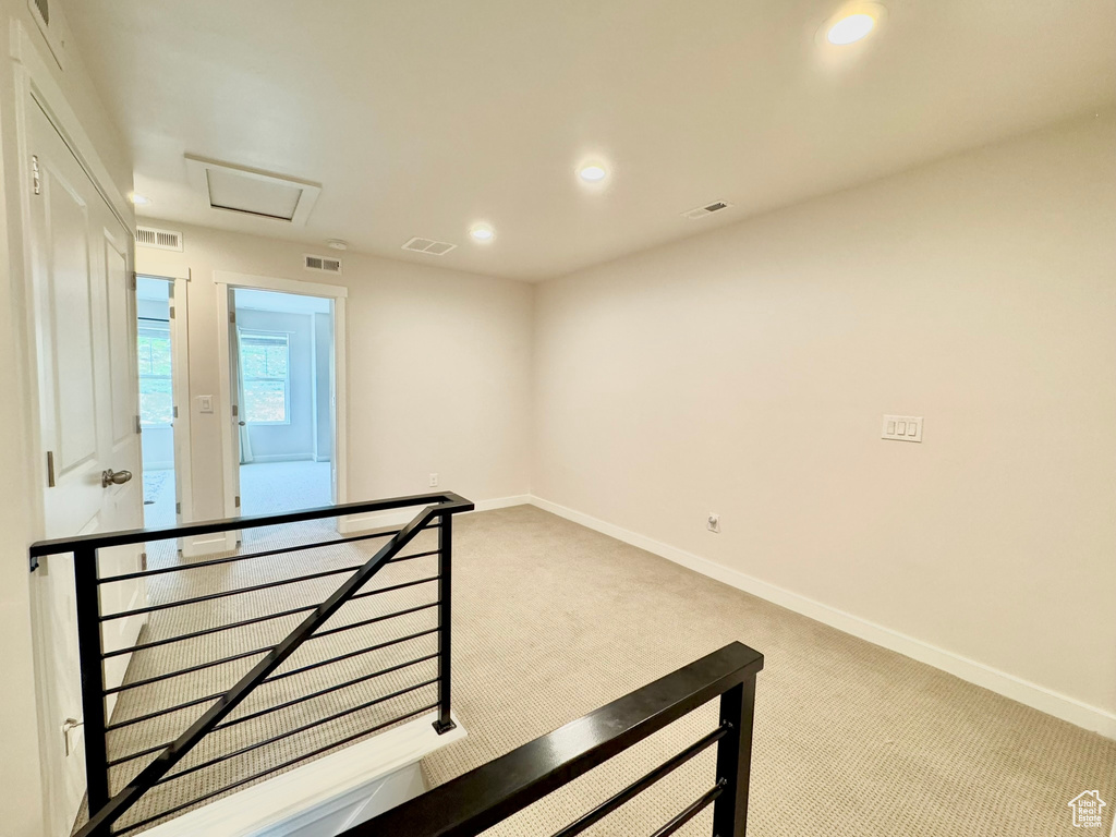 Unfurnished room featuring attic access, carpet, baseboards, and recessed lighting