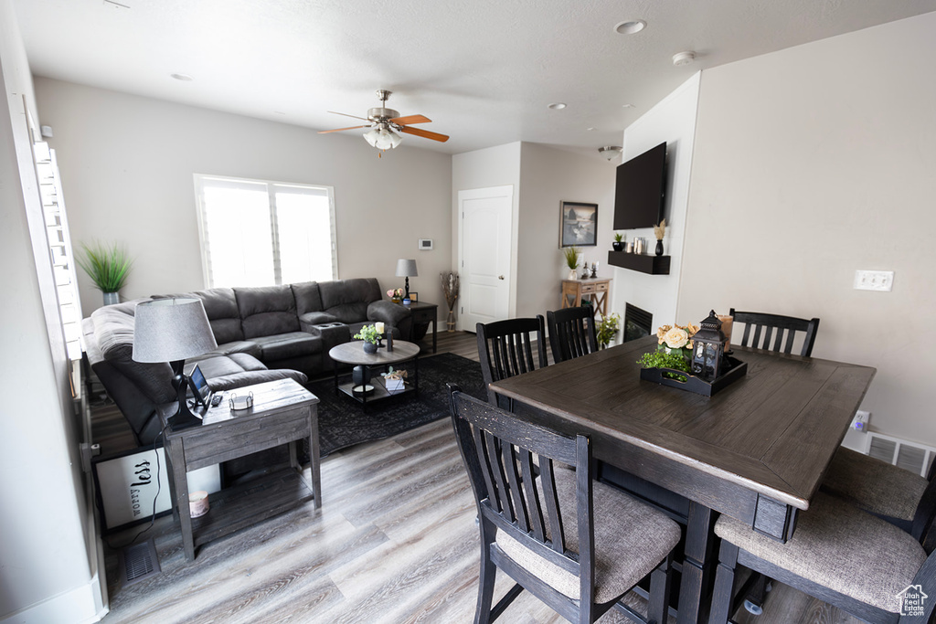 Dining room with light wood-style flooring, a ceiling fan, and visible vents