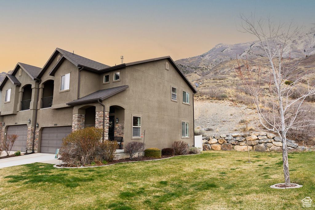 View of front of property with a front yard, a garage, and concrete driveway